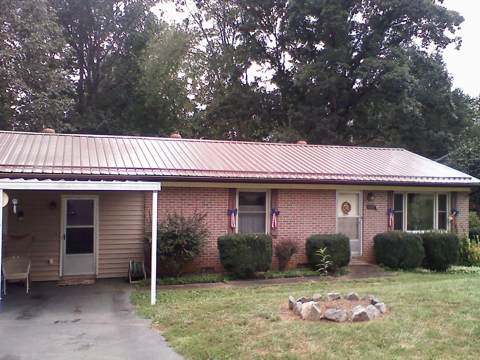 Bronze metal roof and carport on a brick ranch home — Roof Repair work by our crew in Hotchkiss