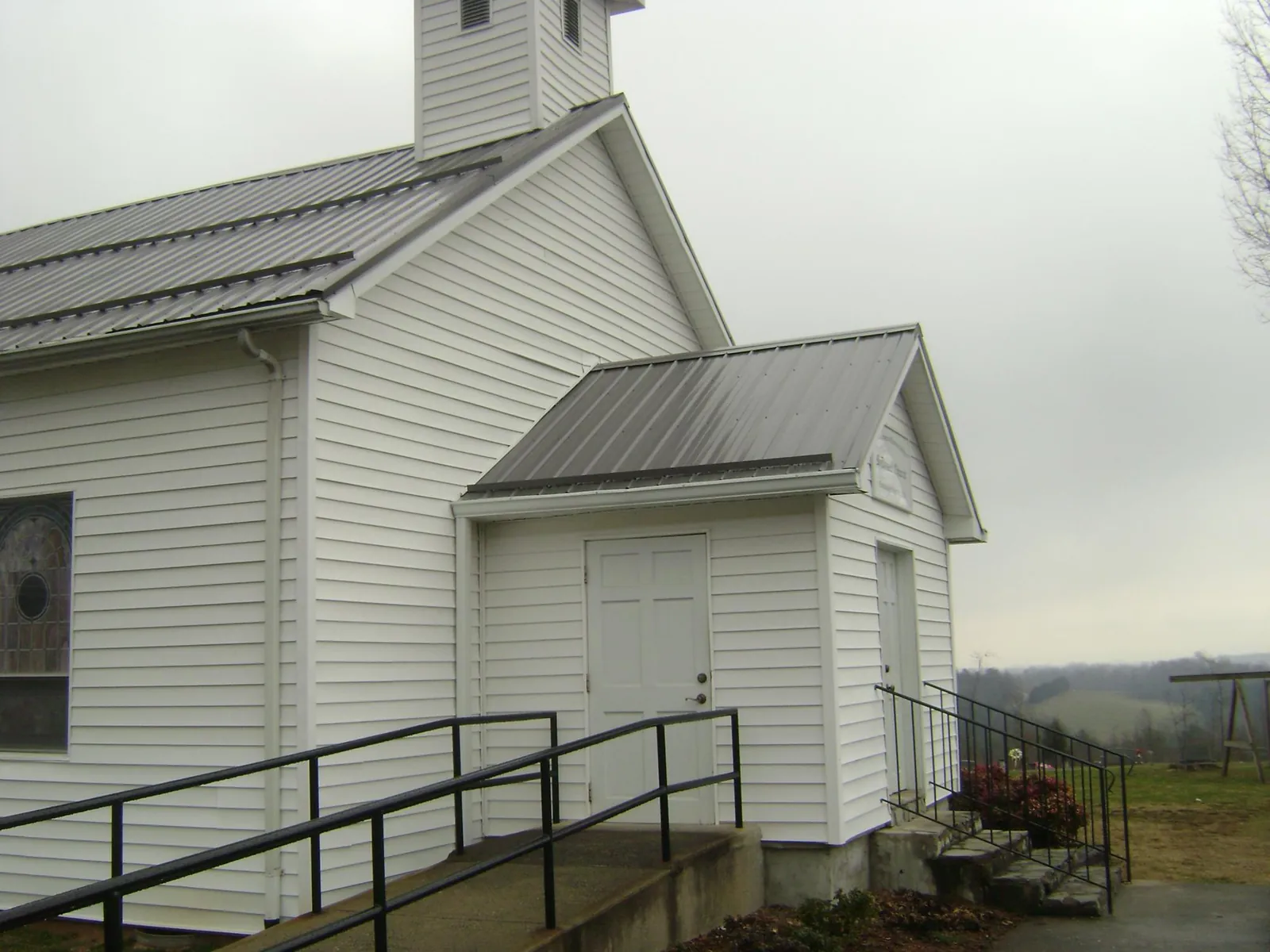 Gray metal roof on a white clapboard church with a steeple in Hotchkiss